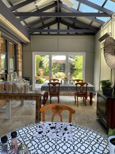 un comedor con mesa y sillas en una habitación en The Nunnery Boutique Hotel en Moss Vale