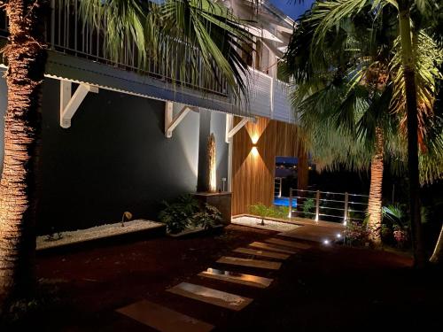 a building with a palm tree in front of it at ZANNANNA LODGE in Le Diamant