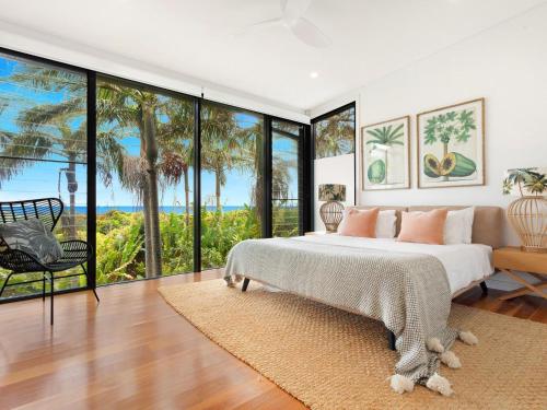 a bedroom with a large bed and large windows at Kiah - nestled between Main & Belongil Beaches in Byron Bay