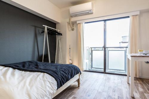 1 dormitorio con cama y ventana grande en Dwell Urban 6D, en Tokio