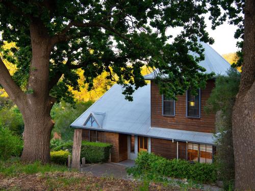 a house with a metal roof and a tree at French Cottage- 2 bedrooms with huge spa in Daylesford