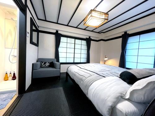 a bedroom with a large bed and a chair at Nozawa Onsen BASECAMP in Nozawa Onsen