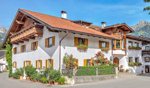 una casa blanca con flores delante en Gintherhof, en Reutte