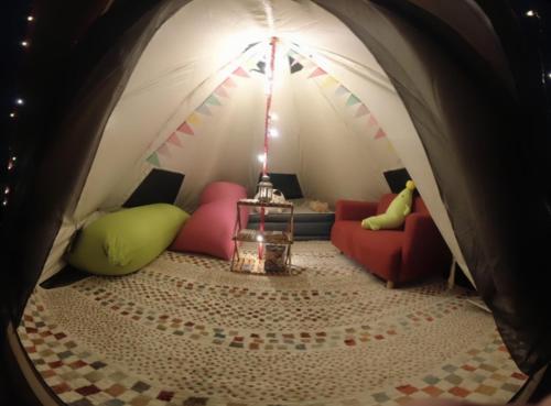 une chambre avec une tente, des canapés et une table dans l'établissement 阿蘇び心 Asobi Gokoro, à Aso