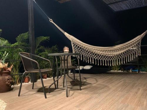 a hammock with chairs and a table and some plants at Verdes Hábitat Glamping in Palestina