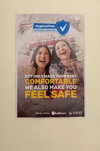 a poster on a wall with two women at Nipa Guest House near Universitas Widyagama Mitra RedDoorz in Blimbing
