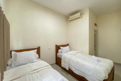 Postel nebo postele na pokoji v ubytování Nipa Guest House near Universitas Widyagama Mitra RedDoorz