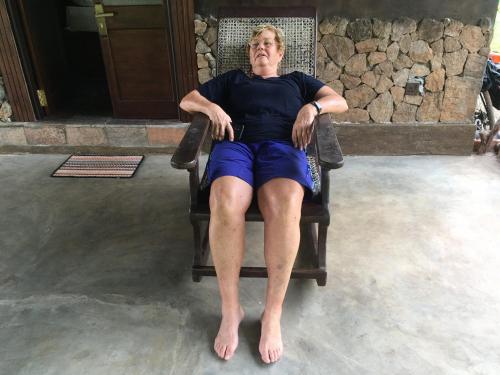 an older man sitting in a chair with his legs crossed at Ceylon Resort in Wilpattu