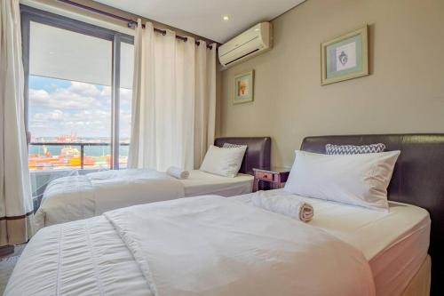 a hotel room with two beds and a window at Executive apartment at Ushaka Marine in Durban