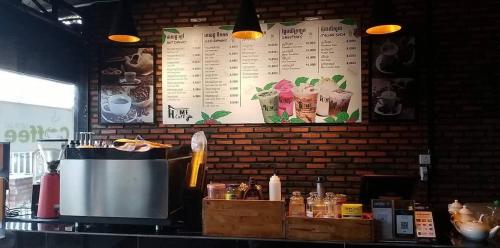 a kitchen with a counter with a pot and a menu at Avocado Guesthouse in Sen Monorom