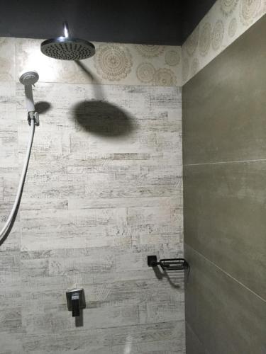 a shower with a shower head in a bathroom at Ceylon Resort in Wilpattu