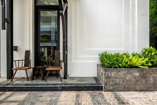 a front porch with two chairs and plants at Amanaki Thao Dien in Ho Chi Minh City