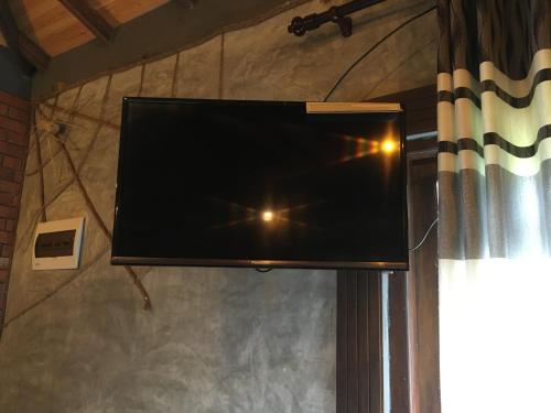 a flat screen tv hanging on a wall at Ceylon Resort in Wilpattu
