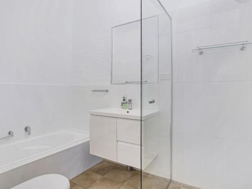 a white bathroom with a sink and a shower at LingaLonga in Hawks Nest
