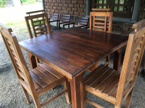 a wooden table and some chairs and a wooden table and chairs at Ceylon Resort in Wilpattu