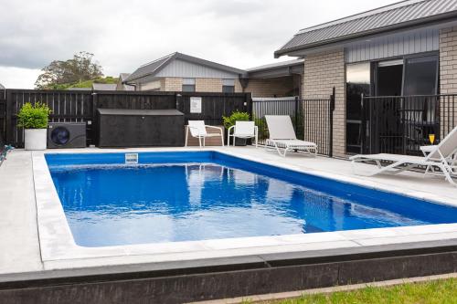 a swimming pool in the backyard of a house at Parkside Boutique Lodge in Rotorua