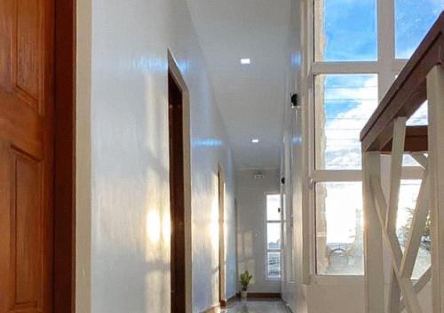 a hallway with a window and a white wall at Leonila's Travellers Inn in Iloilo City