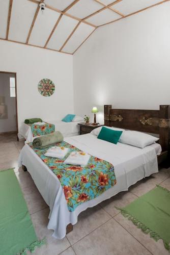 a bedroom with two beds in a room with green mats at Pousada Chácara Rama in Botucatu