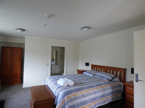 a bedroom with a bed with two towels on it at Sahara Deluxe Studios in Dunedin