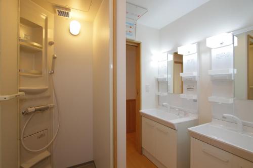 Baño blanco con 2 lavabos y espejo en Fujinokura Village A - Vacation STAY 84886, en Fujikawaguchiko