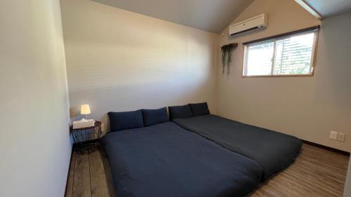 石垣島的住宿－rupo green，一间卧室设有蓝色的床和窗户。