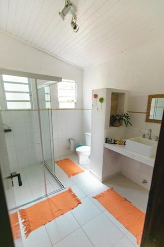 a bathroom with a glass shower and a toilet at Pousada Chácara Rama in Botucatu