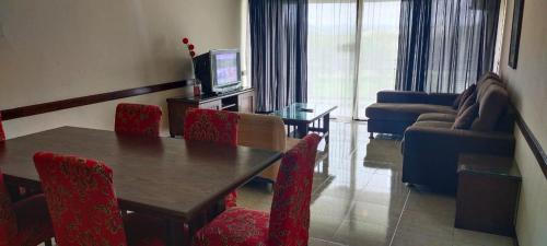 a living room with a table and chairs and a television at Condo D'Savoy A Famosa Resort Melaka Homestay in Kampong Pulau Sebang