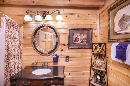 ein Badezimmer mit einem Waschbecken und einem Spiegel an einer Holzwand in der Unterkunft Deer Run in Sevierville
