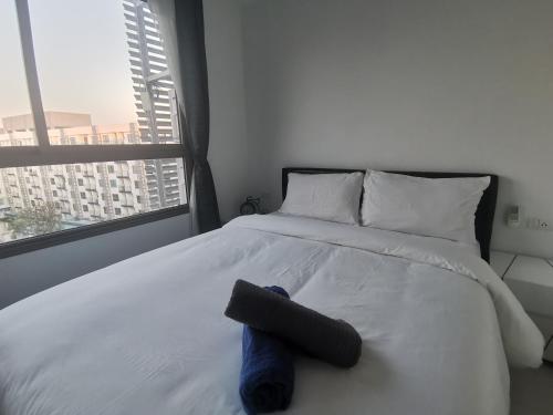 een bed met een knuffeldier erop met een raam bij Super 1BDR in Water Park Resort in Pattaya South