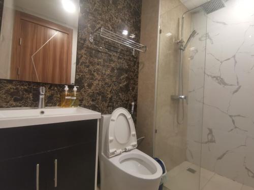 een badkamer met een toilet, een wastafel en een douche bij Super 1BDR in Water Park Resort in Pattaya South