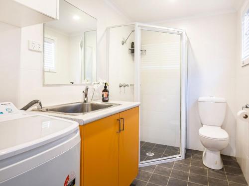 La salle de bains est pourvue d'un lavabo, de toilettes et d'une douche. dans l'établissement Boho Pet Friendly 1 Min Walk to Beach, à Culburra Beach