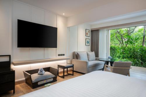 a bedroom with a bed and a living room with a tv at Hyatt Regency Hua Hin in Hua Hin