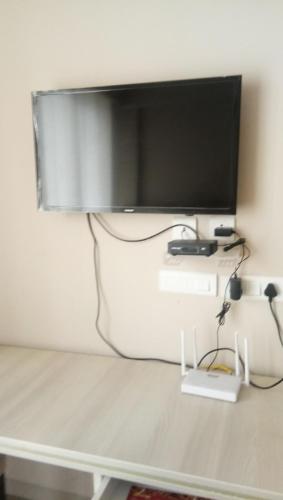 a flat screen tv hanging on a wall at Omaxe Krishna Aavas in Vrindāvan