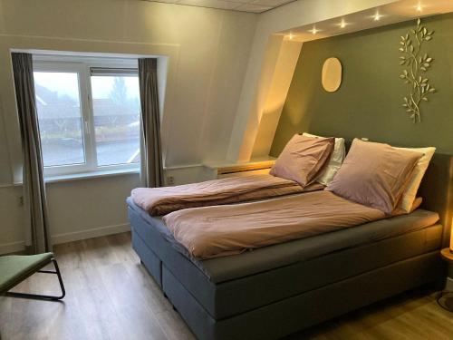 a bed in a room with a window at Hotel Workum in Workum