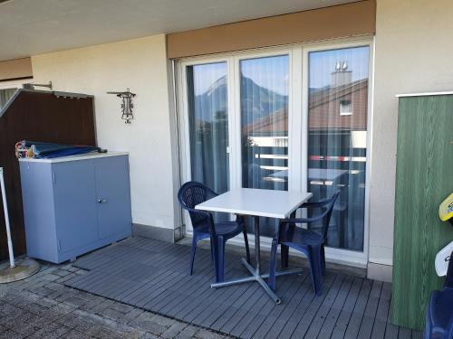a table and chairs on a balcony with a window at Elfe-Apartments Studio Apartment for 2 guests in Emmetten