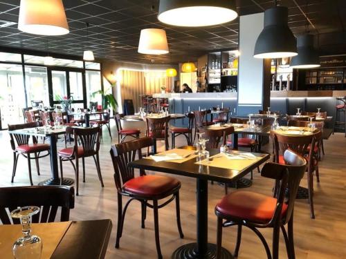 een eetkamer met tafels en stoelen en een restaurant bij Fasthotel L'Eldorado in Sébazac-Concourès