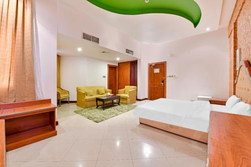 OYO 118 Revira Hotel في المنامة: غرفة نوم مع سرير وغرفة معيشة