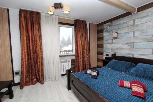 Nord Cottage في يابلونيتسيا: غرفة نوم بسرير ازرق ونافذة