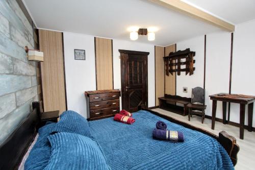 a bedroom with a blue bed with two pillows on it at Nord Cottage in Yablunytsya