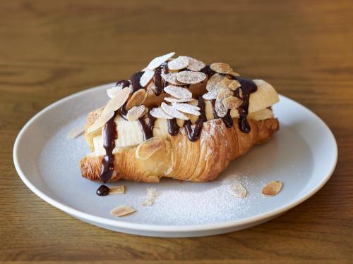 a pastry sitting on a white plate on a table at LAMP LIGHT BOOKS HOTEL fukuoka in Fukuoka