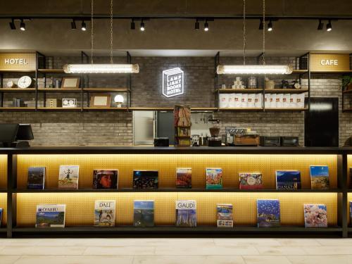 LAMP LIGHT BOOKS HOTEL fukuoka في فوكوكا: مطعم فيه رف عليه مواد غذائية