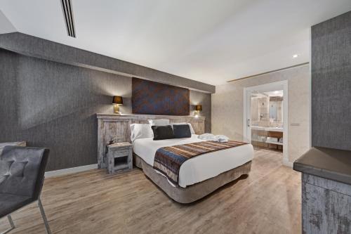 a bedroom with a large bed and a chair at Castilla Termal Monasterio de Valbuena in Valbuena de Duero