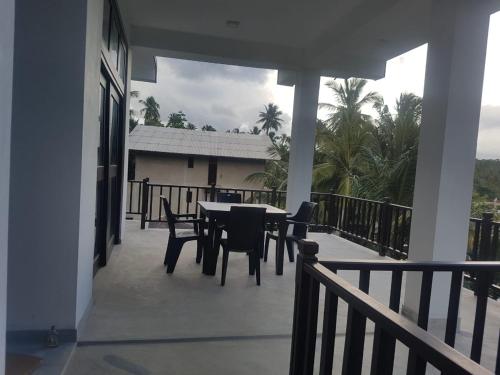 a patio with a table and chairs on a balcony at Waves Hiri Sea View in Hiriketiya