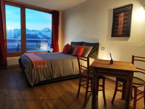 a bedroom with a bed and a table and a window at Studiò Pila 1800 in Pila
