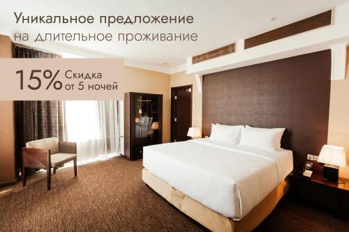 - une chambre avec un grand lit blanc et une chaise dans l'établissement Four Elements Perm, à Perm