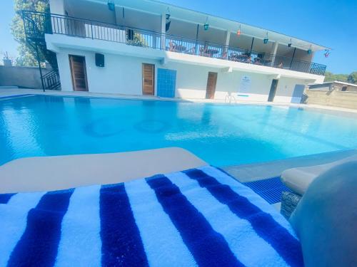 a large swimming pool with a building in the background at Hotel Comster Mtwapa in Mtwapa