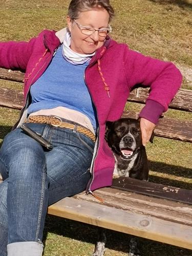 a woman sitting on a bench with a dog at Landhaus Marie in Hermagor