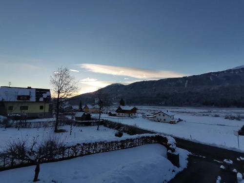 a village covered in snow with the sunset in the background at Landhaus Marie in Hermagor