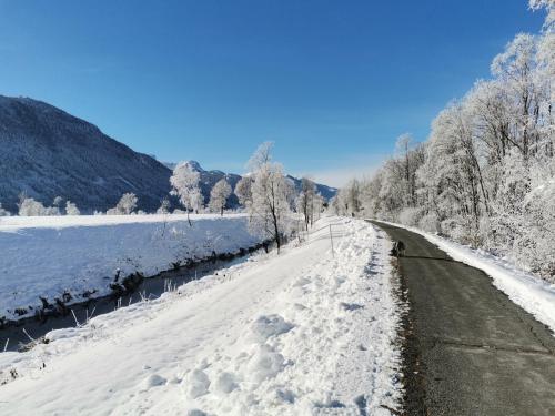 a road covered in snow next to a river at Landhaus Marie in Hermagor