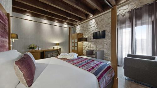 a hotel room with a bed and a desk at Castilla Termal Monasterio de Valbuena in Valbuena de Duero